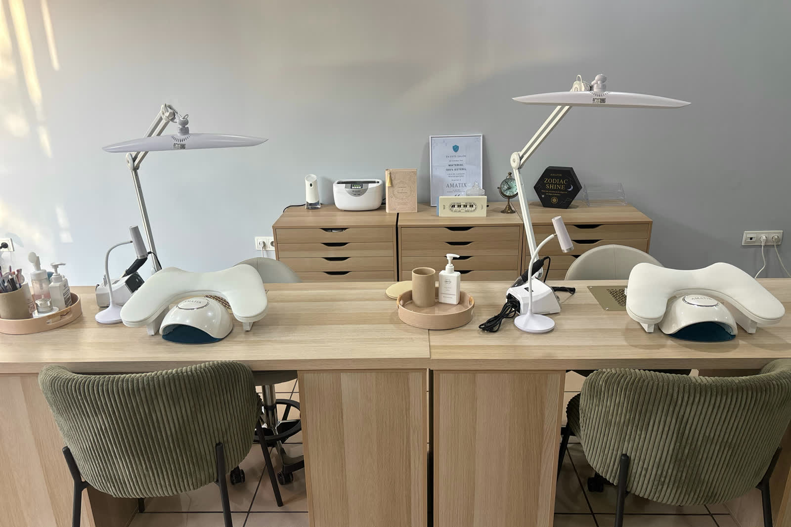 Interior del salón: los dos puestos de manicura, en madera clara y con lámparas de trabajo