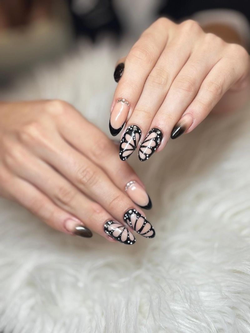 Uñas negras con mariposa translúcida