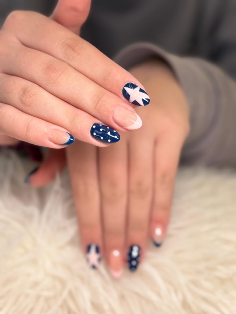 Uñas azul marino con estrellas y punta francesa rosa